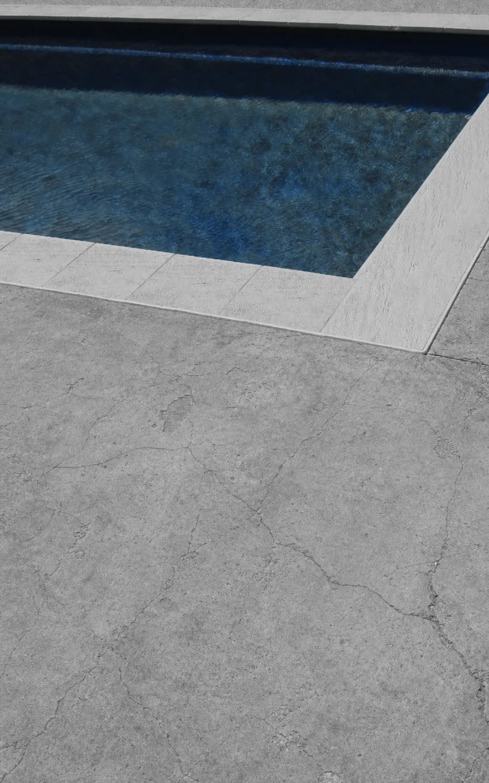 Cracked concrete pool surround in Adelaide before resin-bound resurfacing